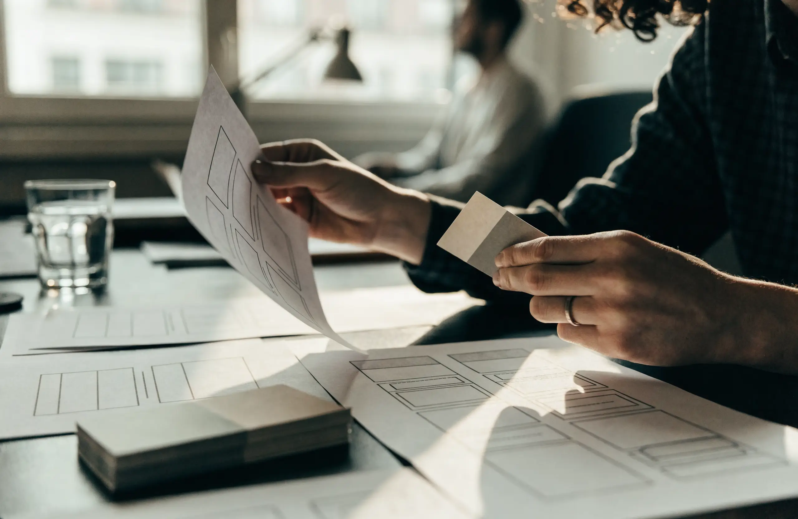 Web designer arranging website wireframe sketches on a desk