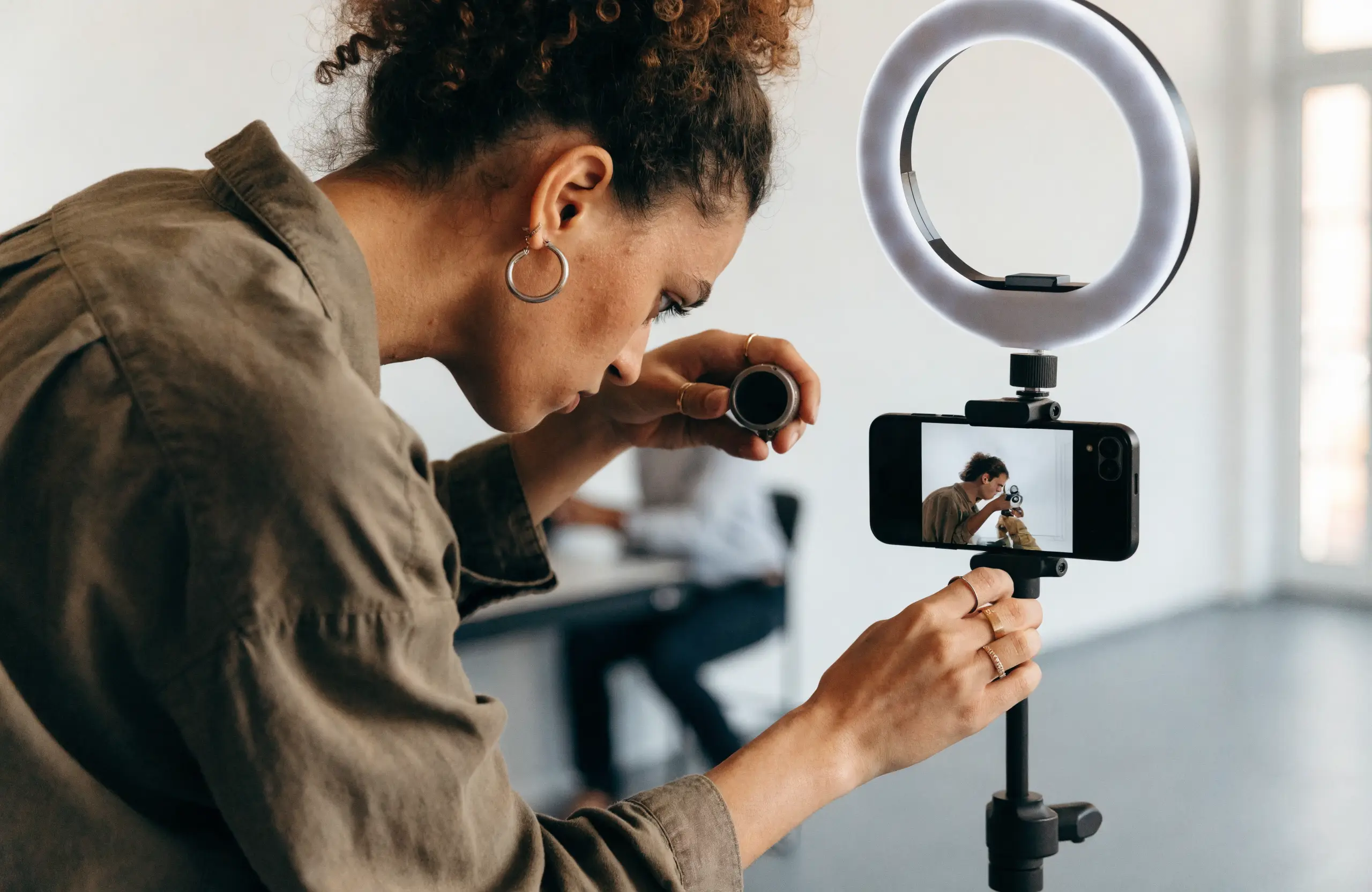 Content creator filming product creative for social ads with a ring light