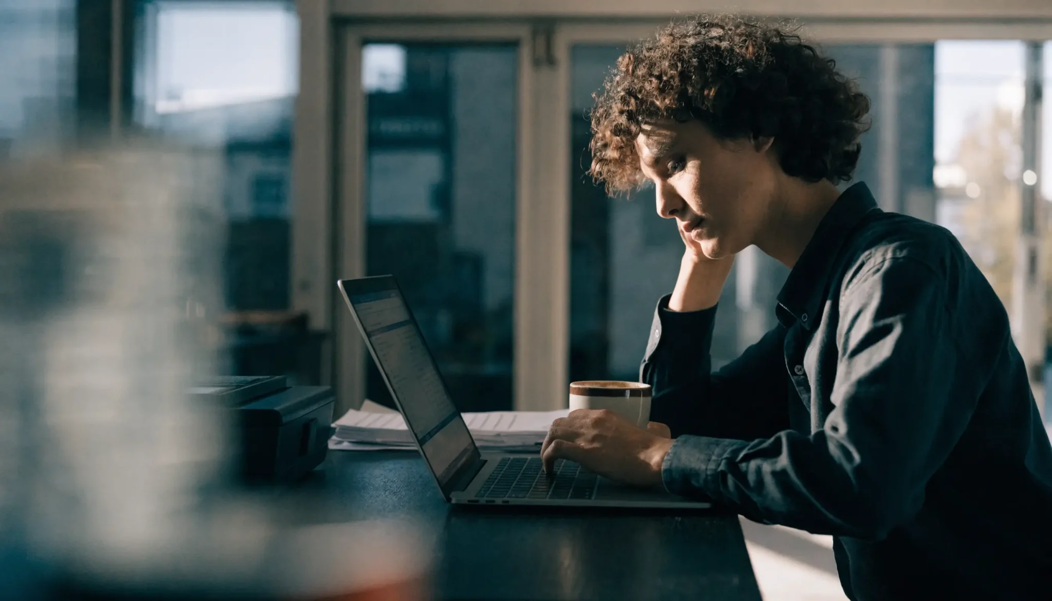 google-ads-cost-review - Caffeinate Digital Small business owner reviewing Google Ads spend on a laptop