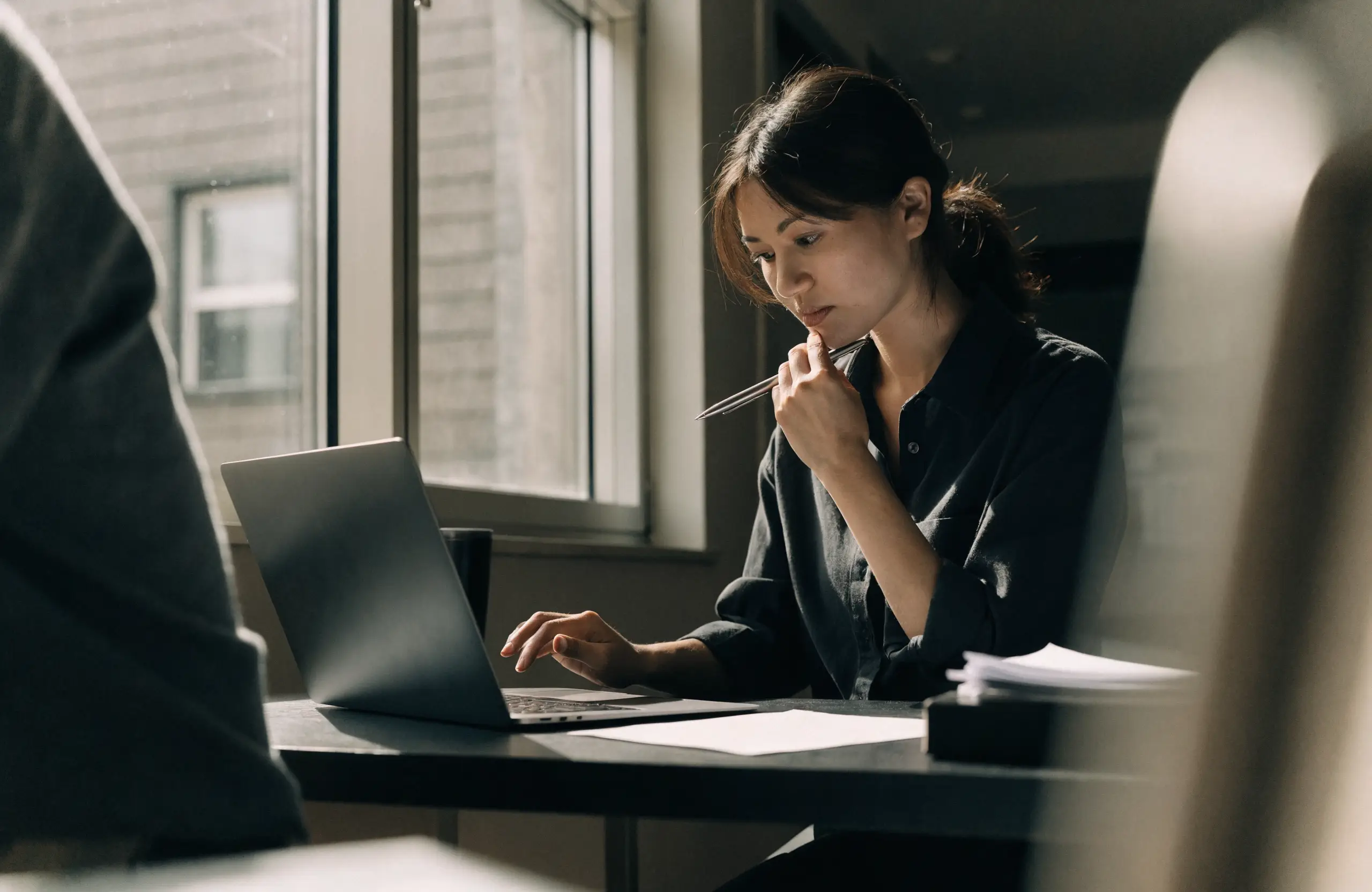 Content strategist refining answer-first website copy on a laptop